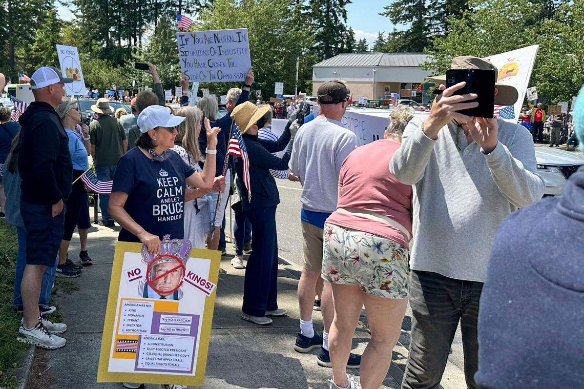 Demonstrators gathered at the corner of Point Fosdick Drive & Olympic Drive in Gig Harbor, Wash., on Saturday, June 14, 2025, for the No Kings rally.