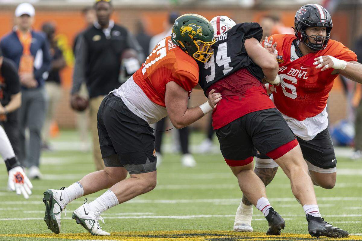 Jan 30, 2025; Mobile, AL, USA; National team offensive lineman Grey Zabel of North Dakota State (77) and National team offensive lineman Caleb Rogers of Texas Tech (76) battle with National team defensive lineman Ty Robinson of Nebraska (94) during Senior Bowl practice for the National team at Hancock Whitney Stadium. Mandatory Credit: Vasha Hunt-Imagn Images