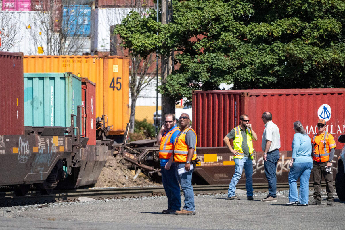 Crews from Burlington Northern-Santa Fe Railroad and Tacoma Rail stand near a derailment near the corner of Port of Tacoma Road and Lincoln Avenue on Wednesday, Aug. 24, 2022, in Tacoma. No injuries were reported in the accident.