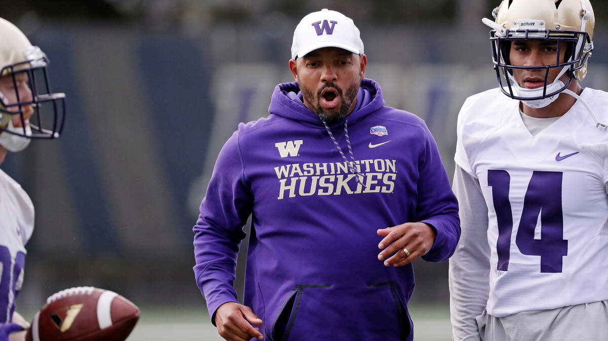 Washington co-defensive coordinator Jimmy Lake works with players at the first practice of spring football for the NCAA college team Wednesday, March 28, 2018, in Seattle. (AP Photo/Elaine Thompson)
