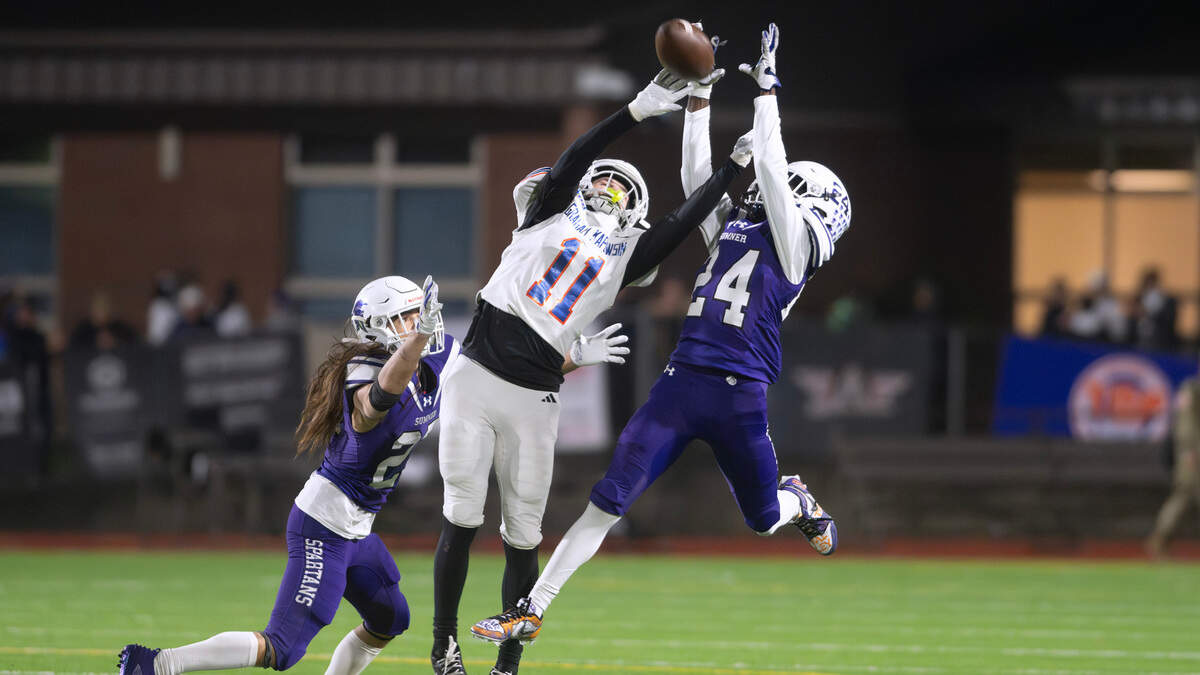 Sumner defensive back Jayden Benson (24) grabs an interception over Graham Kapowsin wide receiver Kase Betz during Friday night’s football game at Sunset Chev Stadium in Sumner, Washington, on Nov. 1, 2024. Sumner won the game, 23-11.
