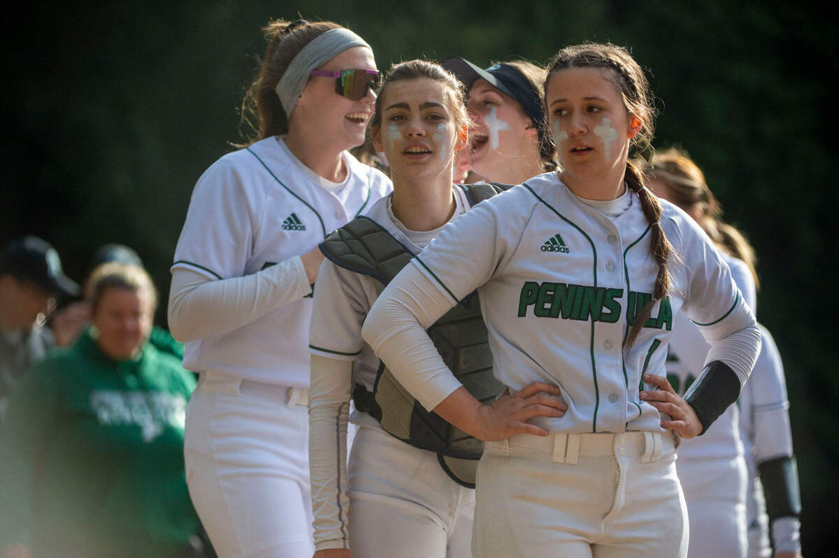 The Peninsula battery of Alli Kimball (right) and catcher Hailey Ruckle (center) stand at the front of the line to shake hands with Gig Harbor players after beating the Tides, 6-0, in a 3A South Sound Conference game on Wednesday, April 6, 2022, at Peninsula High School in Gig Harbor, Wash.