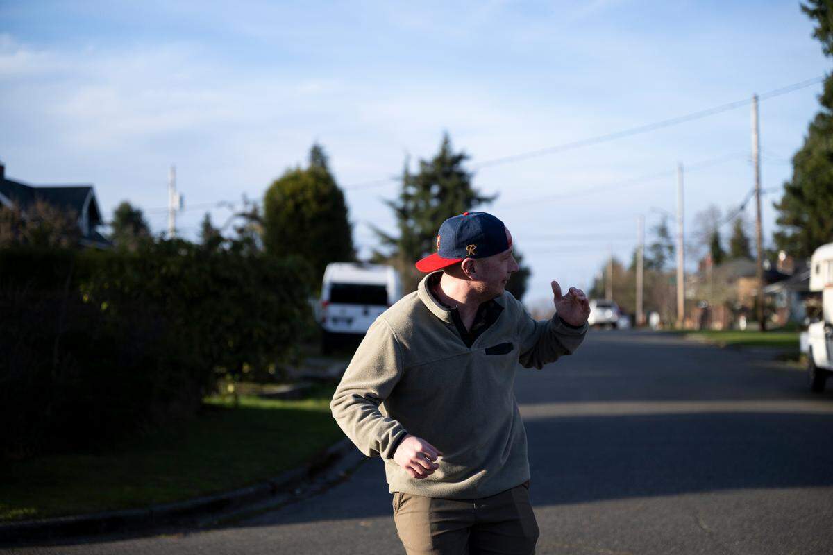 Kevin Larson reenacts the attack by a barred owl that he survived while going for a jog in the early morning hours of Dec. 13, 2023, in Tacoma, Wash.