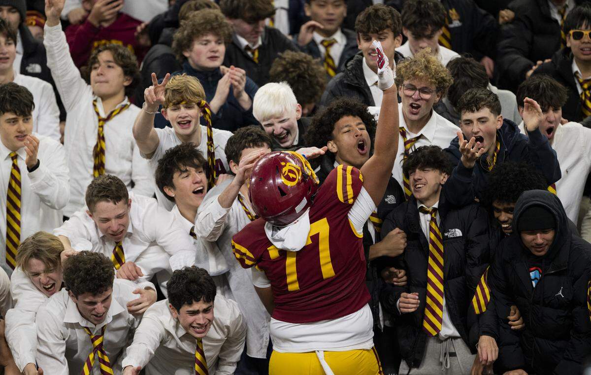 O'Dea offensive lineman Tanu Noa (77) jumps into the student section after O’Dea’s 21-14 win against Mt. Tahoma in the 3A State Championship game at Husky Stadium, on Friday, Dec. 5, 2025, in Seattle.