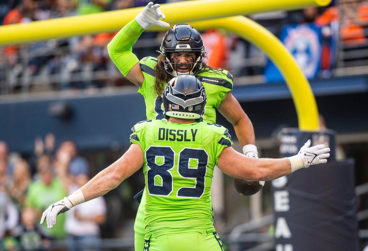 Seattle Seahawks tight end Colby Parkinson (84) celebrates with Seattle Seahawks tight end Will Dissly (89) in the end zone after scoring a touchdown before the end of the second quarter of an NFL game on Monday, Sept. 12, 2022, at Lumen Field in Seattle.