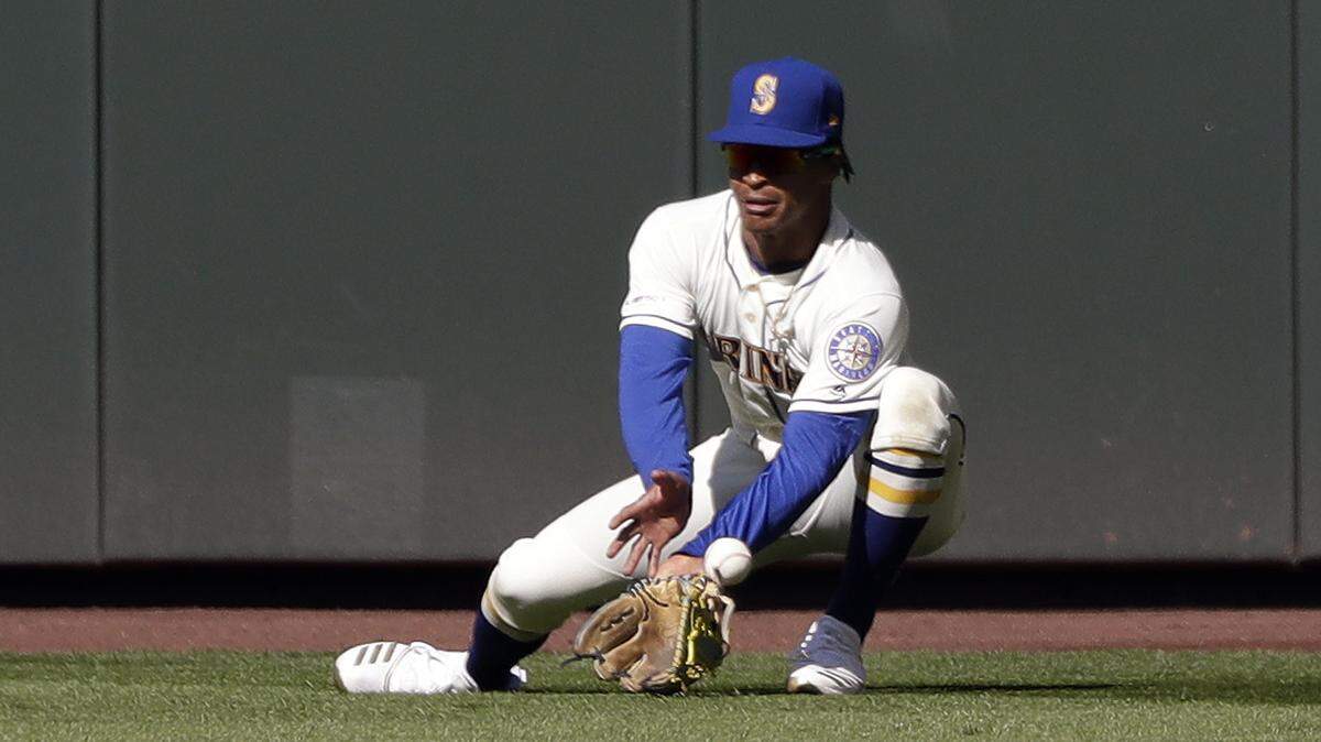 Seattle Mariners center fielder Mallex Smith misplays a fly ball from Texas Rangers’ Elvis Andrus for an error in the ninth inning of a baseball game Sunday, April 28, 2019, in Seattle. (AP Photo/Elaine Thompson)