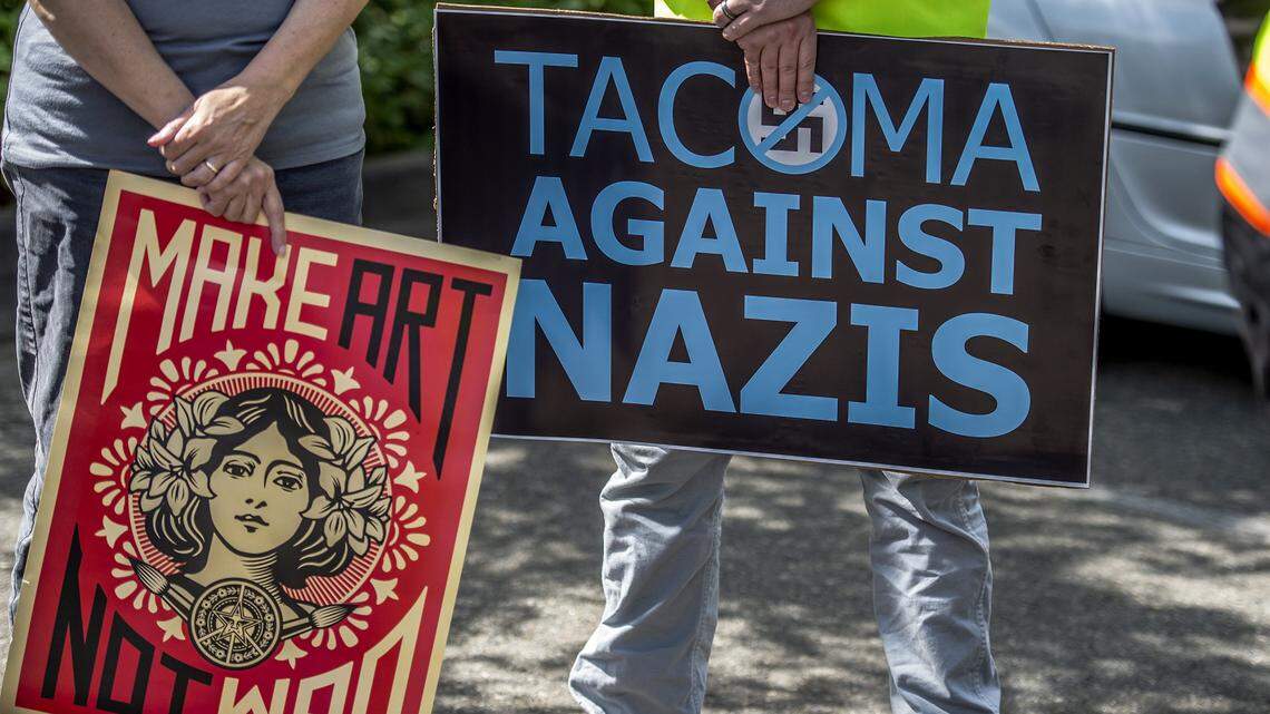 About 3 dozen people gathered on E 72nd Street in Tacoma, Wash., Friday, June 23, 2018, to protest the flying of Nazi flags at a Tacoma tattoo establishment.