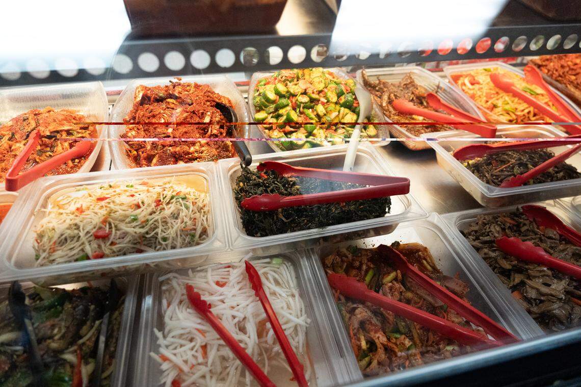 A bar near the front of the store features different types of kimchi and other dishes.