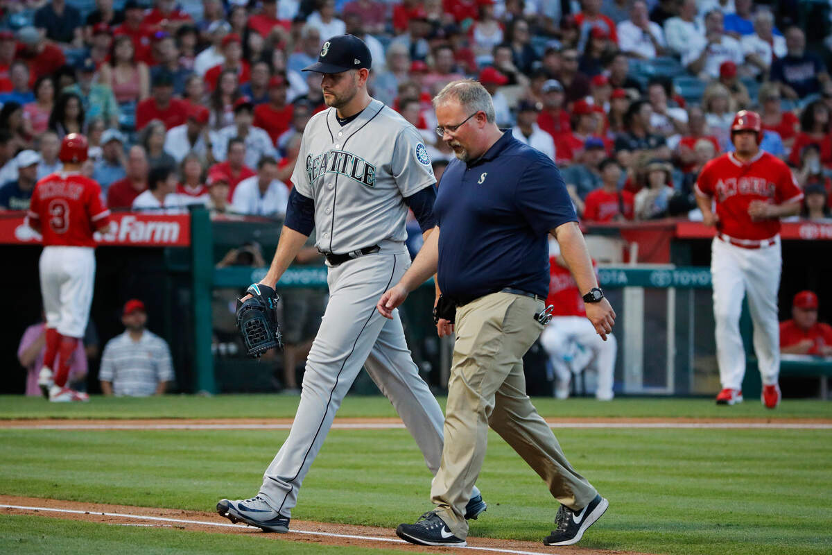 Seattle Mariners starting pitcher James Paxton, left, and a trainer walk off the field after he was removed during the first inning of the team’s baseball game against the Los Angeles Angels, Thursday, July 12, 2018, in Anaheim, Calif. (AP Photo/Jae C. Hong)