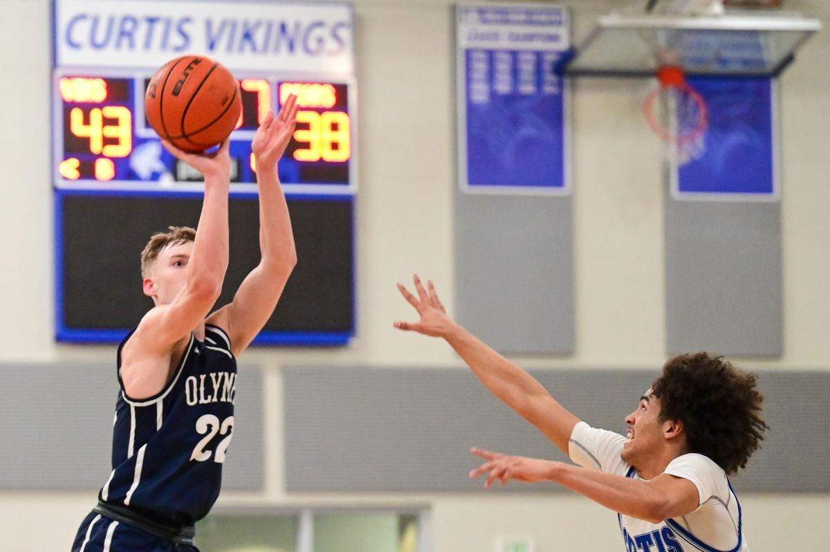 Olympia guard Parker Gerrits (22) attempts a 3-pointer as Curtis guard Gabe Martin (2) defends during the fourth quarter of a 4A South Puget Sound League game on Friday, Jan. 21, 2022, at Curtis High School in University Place, Wash. Gerrits made the shot to cut the Curtis lead to just 2 points late in the game.