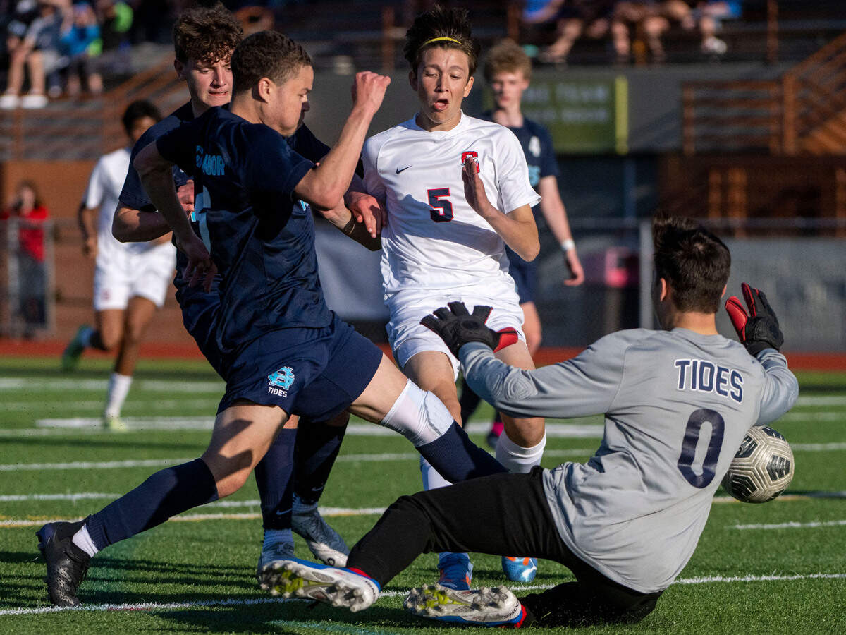 Gig Harbor defender Caleb Gilbert kicks the ball away from Silas’ Caden Grant as dribbles toward keeper Gavin Boudet during the second half of the 3A West Central/Southwest district soccer championship game on Thursday, May 11, 2023, at Sparks Stadium in Puyallaup, Wash.