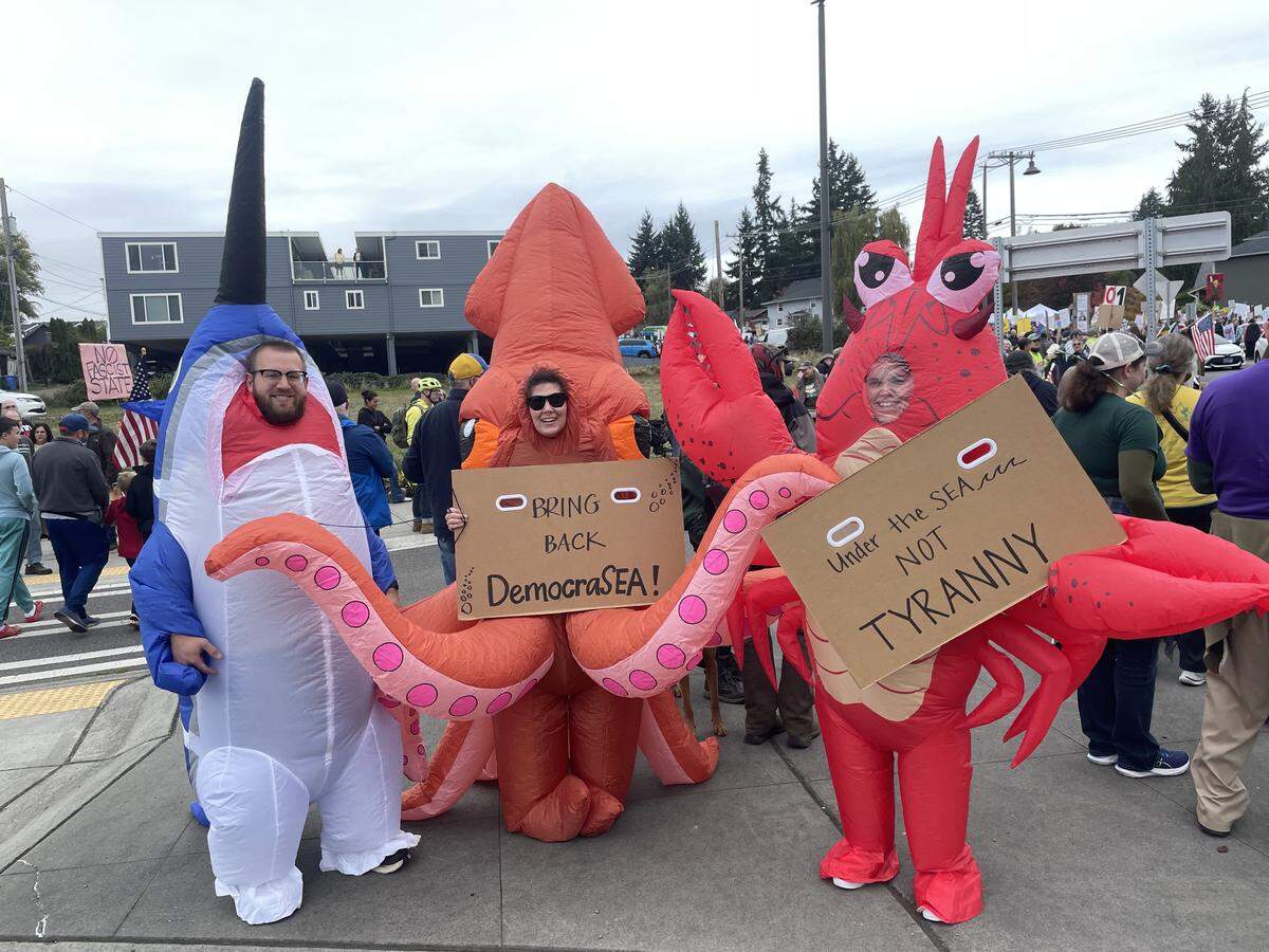 Tacoma couple Jake (dressed as a sailfish) and Jenelle (dressed as a lobster), attended the No Kings protest near Point Defiance with Jenelle’s sister Ashleigh (who was dressed as a squid) on Oct. 18, 2025. The group declined to share their last names, out of concern for retaliation from the current administration.