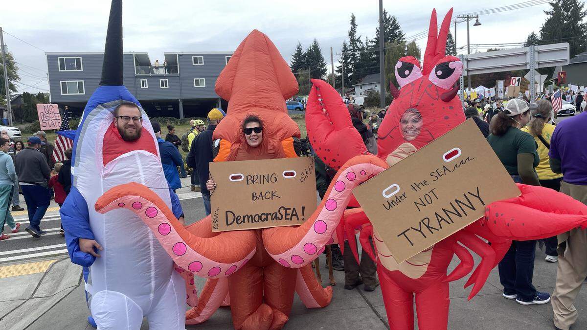 Tacoma couple Jake (dressed as a sailfish) and Jenelle (dressed as a lobster), attended the No Kings protest near Point Defiance with Jenelle’s sister Ashleigh (who was dressed as a squid) on Oct. 18, 2025. The group declined to share their last names, out of concern for retaliation under the current administration.