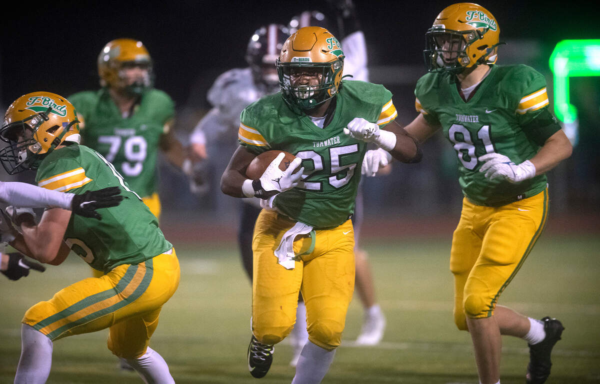 Tumwater running back Carlos Matheney finds running room between blockers Charles Crawford (left) and Beckett Wall during Friday night’s Pioneer Bowl crosstown rivalry football game against the Black Hills Wolves at Tumwater District Stadium in Tumwater, Washington, on Oct. 28, 2022.