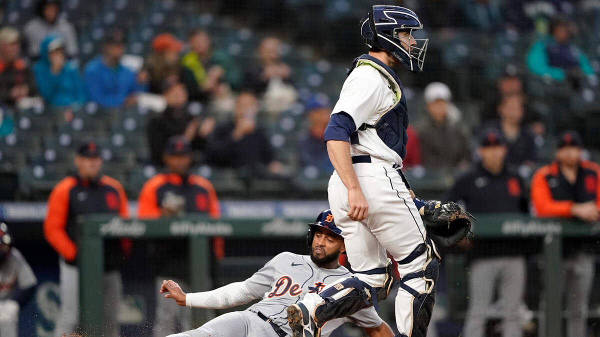 Detroit Tigers’ Willi Castro, left, scores past Seattle Mariners catcher Tom Murphy on a single by Harold Castro during the fourth inning of a baseball game Wednesday, May 19, 2021, in Seattle. (AP Photo/Ted S. Warren)