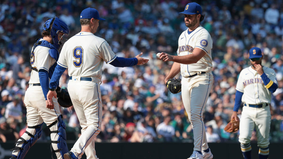 Seattle Mariners starting pitcher Robbie Ray, front right, hands the ball to manager Scott Servais (9) as he comes out of a baseball game during the sixth inning against the Oakland Athletics, Sunday, Oct. 2, 2022, in Seattle. (AP Photo/Jason Redmond)
