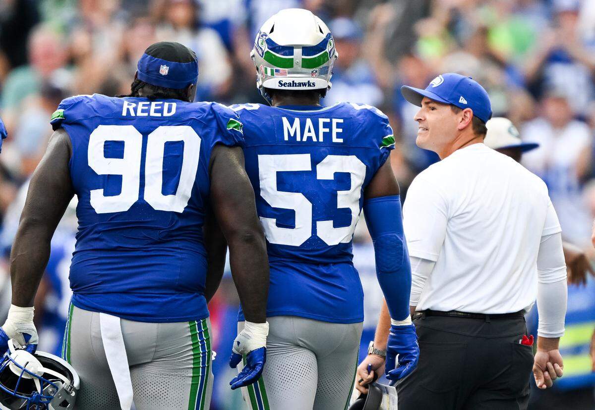 Seattle Seahawks defensive tackle Jarran Reed (90), linebacker Boye Mafe (53) and head coach Mike Macdonald walk along the sidelines during the fourth quarter of the game against the Denver Broncos at Lumen Field, on Sunday, Sept. 8, 2024, in Seattle, Wash.