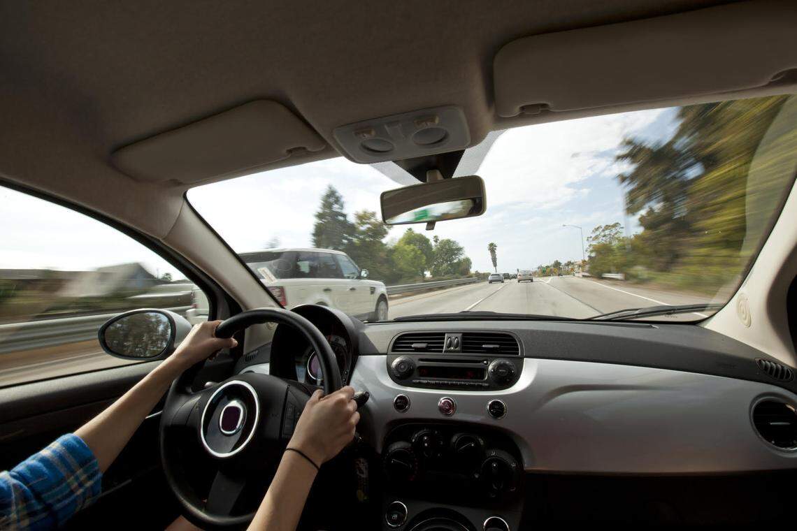 A woman driving a small car