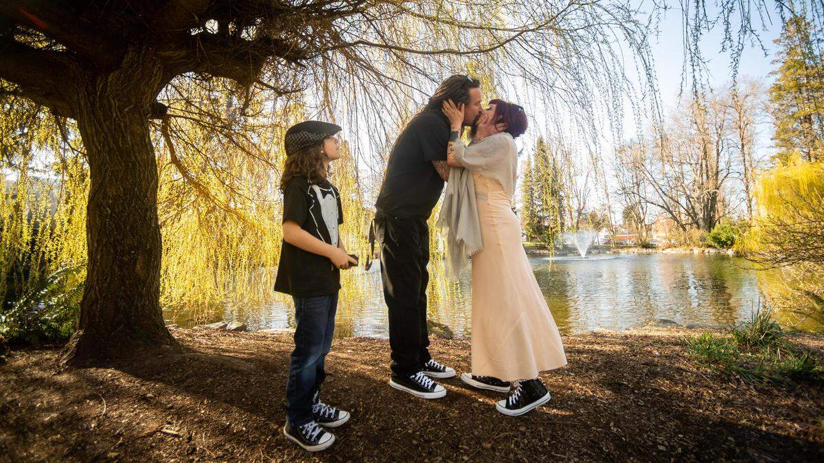 Cornelius Epling, left, and Tara Epling-Schnitzer, right, kiss after being pronounced husband and wife under a weeping willow tree at Wright Park in Tacoma, Wash., on Thursday, March 19, 2020.