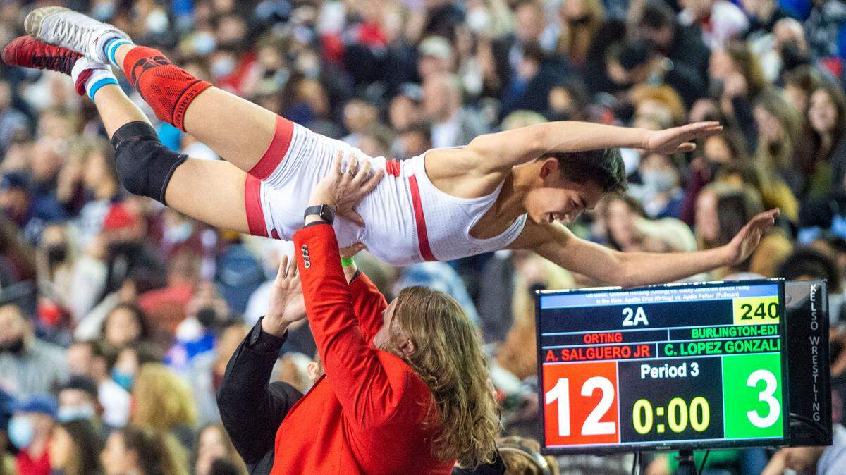 Orting head coach Jody Coleman lifts up Alan Salguero, Jr. after he beat Burlington Edison’s Chris Lopez Gonzales, 12-3, in the 106-pound 2A championship match at Mat Classic XXXIII on Saturday, Feb. 19, 2022, at the Tacoma Dome in Tacoma, Wash.