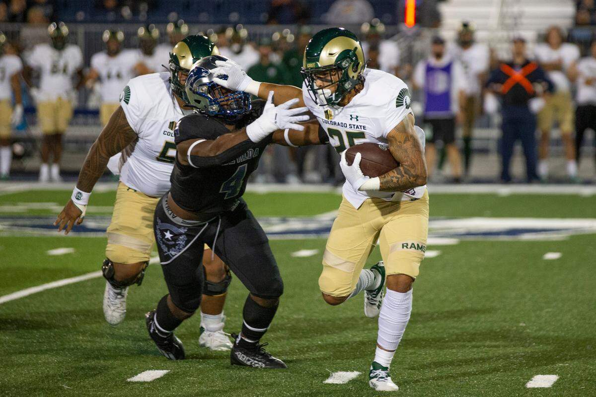 Colorado State running back Avery Morrow (25) stiff-arms Nevada linebacker Eli’jah Winston (4) iduringthe first half of an NCAA college football game in Reno, Nev., Friday, Oct. 7, 2022. (AP Photo/Tom R. Smedes)