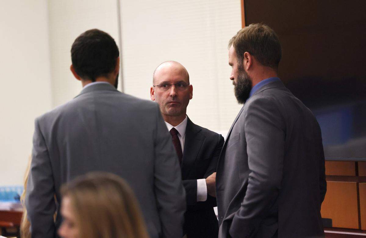 Defense attorney Jared Ausserer, center, speaks with Tacoma police officers Christopher Burbank, left, and Matthew Collins, right in Pierce County Superior Court Thursday Nov. 16, 2023, in Tacoma, WA. Officers Christopher Burbank, Matthew Collins and Timothy Rankine are charged with the death of Manny Ellis. 225515