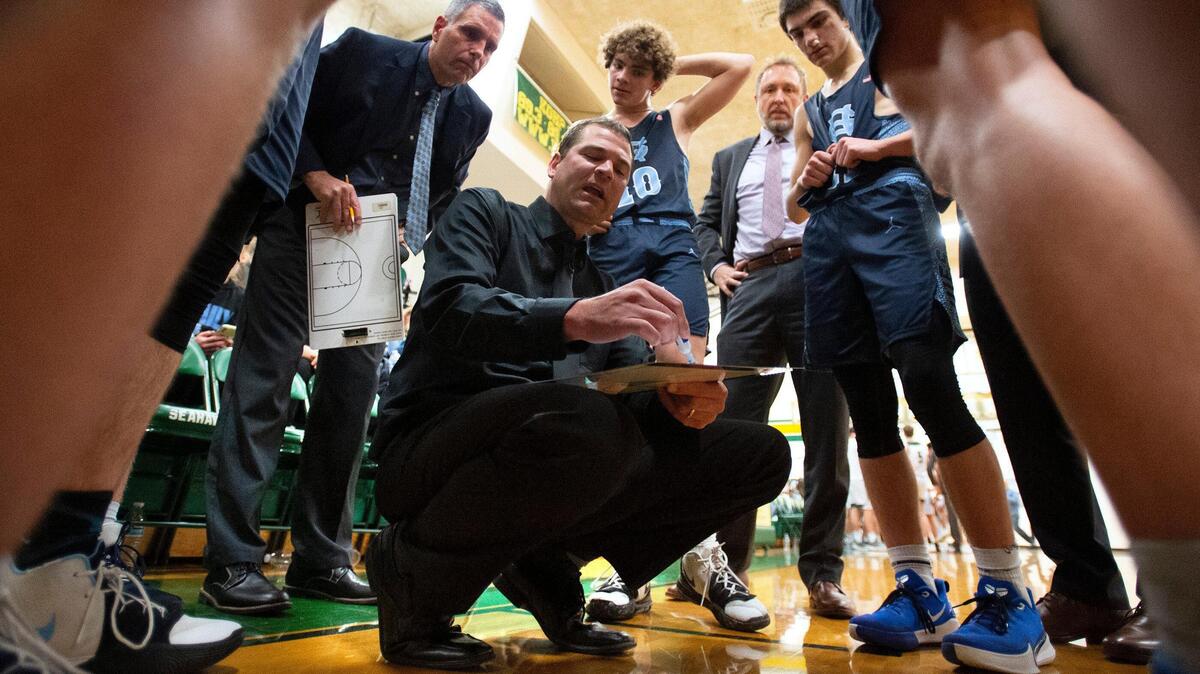Gig Harbor boys basketball head coach Billy Landram directs the Tides during a timeout in Wednesday night’s boys basketball game of the crosstown rivalry double header at Peninsula High School in Gig Harbor on Jan. 14, 2020.