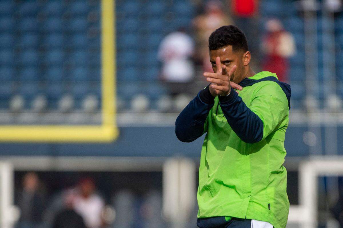 Seattle Seahawks quarterback Russell Wilson (3) points to spots in the end zone as he warms up prior to the start of an NFL game against the San Francisco 49ers on Sunday at Lumen Field in Seattle.