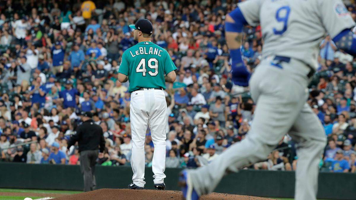Seattle Mariners starting pitcher Wade LeBlanc stands on the mound as Los Angeles Dodgers’ Yasmani Grandal, right, rounds the bases on a solo home run during the third inning of a baseball game Friday, Aug. 17, 2018, in Seattle. (AP Photo/Ted S. Warren)