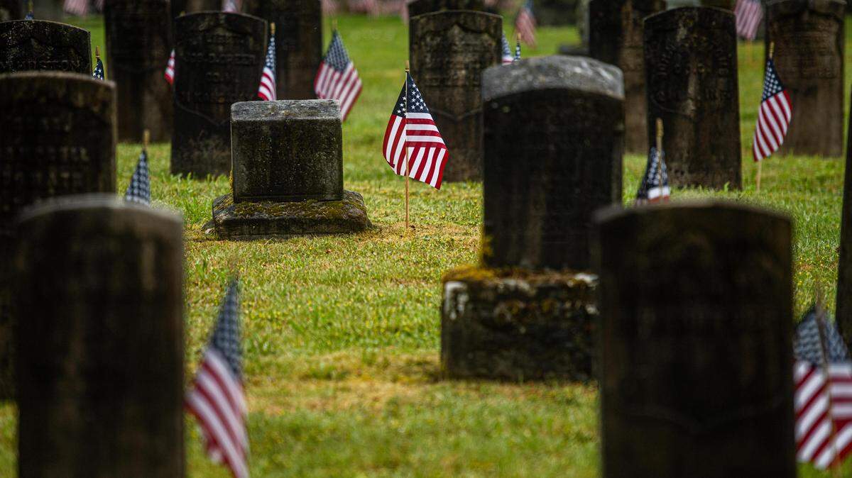 Flags mark the gravesites of veterans at Oakwood Hill Cemetery in Tacoma on Monday, May 25, 2020.
