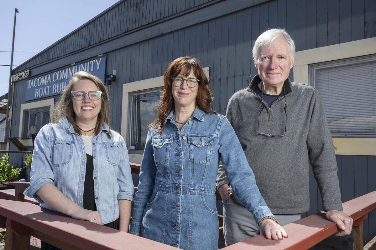 Sara Zier, left, a member of Tacoma Boat Builders board of directors, Shannon Shea, center, executive director of Tacoma Boat Builders, and Paul Birkey, the founder of Tacoma Boat Builders, stand for a portrait outside of the organization on Friday, April 24, 2026, in Tacoma, Wash.