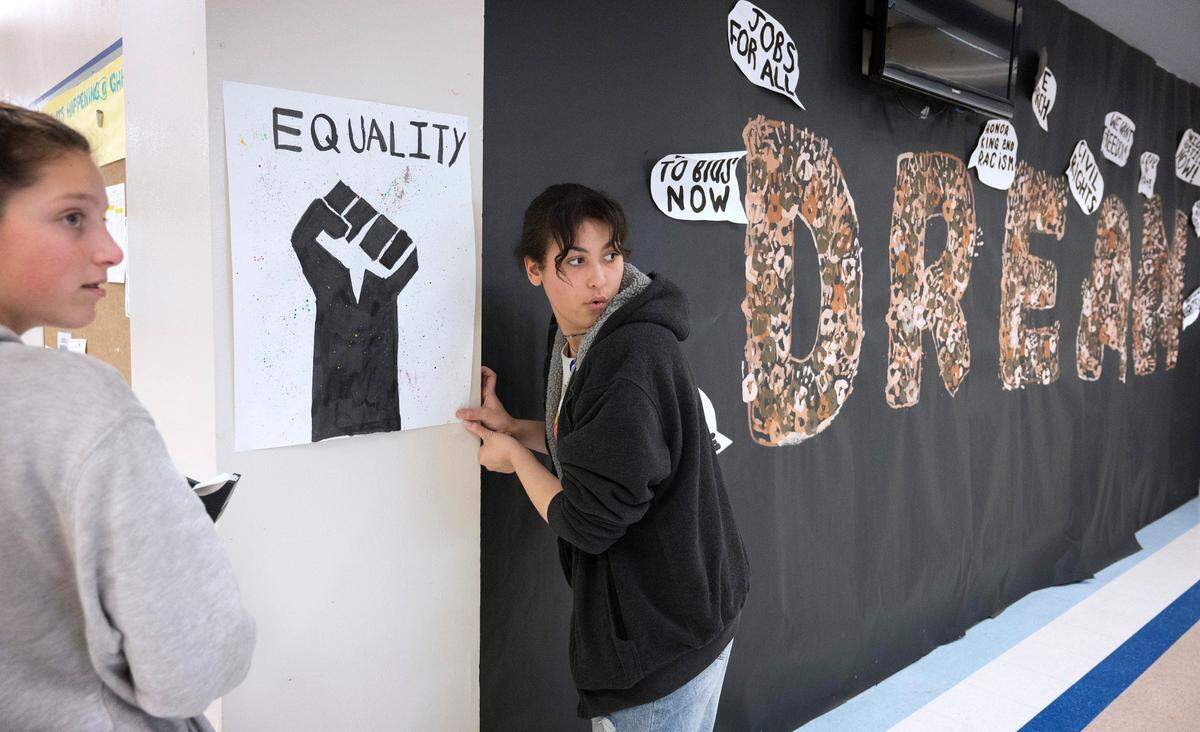 Gig Harbor High freshman Anna Bartlett (left) and senior Tori Burgess hang posters during the weekly meeting of the Black Student Union in Gig Harbor, Washington, on Tuesday, Feb. 7, 2023.