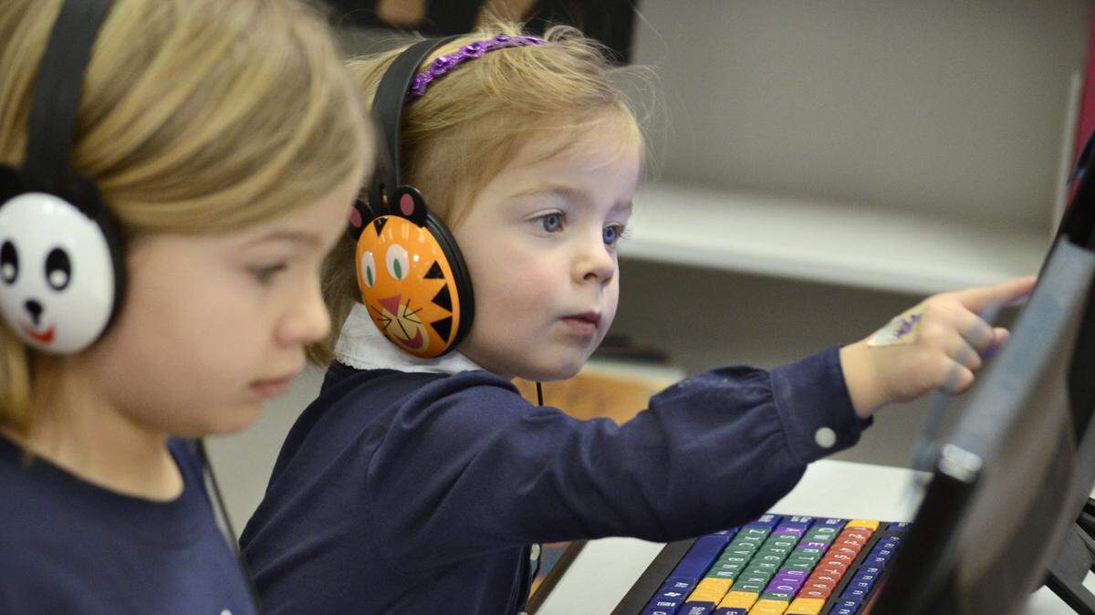 Evalie Mandura, 6, left, and her sister, Elizabeth, 3, concentrate while playing educational games on computers, Wednesday, Jan. 29, 2014, in the Children’s/Youth Services room at the Marion Public Library in Marion, Ind. (AP Photo/Chronicle-Tribune, Jeff Morehead)