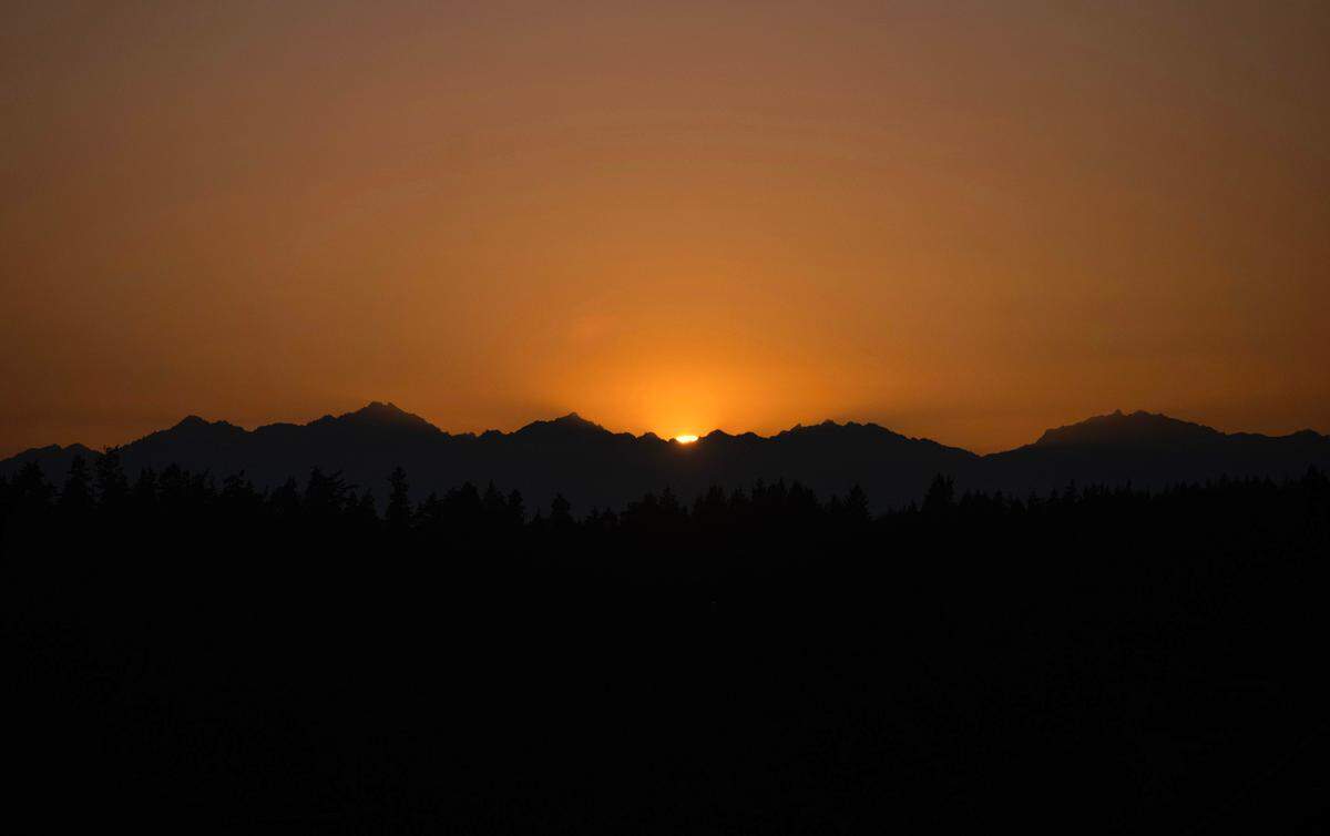 The sun sets over the Olympic Mountains as seen from Tacoma’s west slope on Saturday, July 13, 2024.
