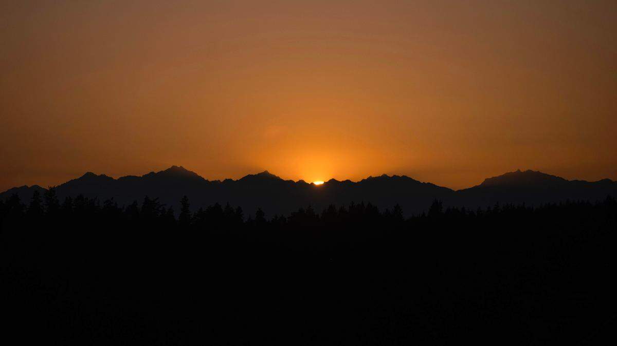 The sun sets over the Olympic Mountains as seen from Tacoma’s west slope on Saturday, July 13, 2024.
