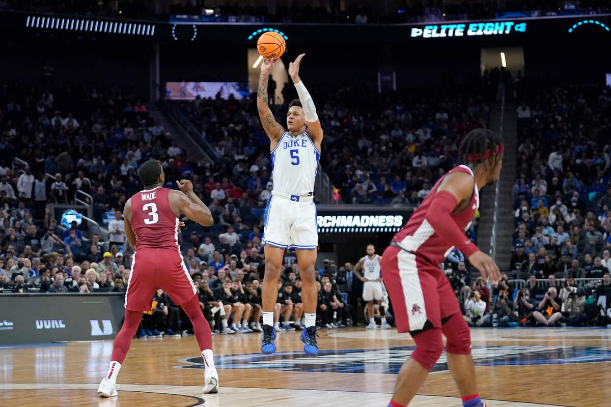Duke forward Paolo Banchero (5) shoots a three point basket against Arkansas forward Trey Wade (3) during the first half of a college basketball game in the Elite 8 round of the NCAA men’s tournament in San Francisco, Saturday, March 26, 2022. (AP Photo/Marcio Jose Sanchez)