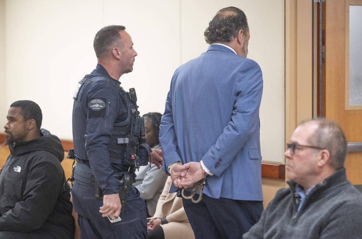 Former Pierce County Sheriff’s Office Maj. Chadwick Dickerson is walked out of court in custody following a plea hearing and sentencing on Tuesday, April 14, 2026, at Pierce County Superior Court in Tacoma.
