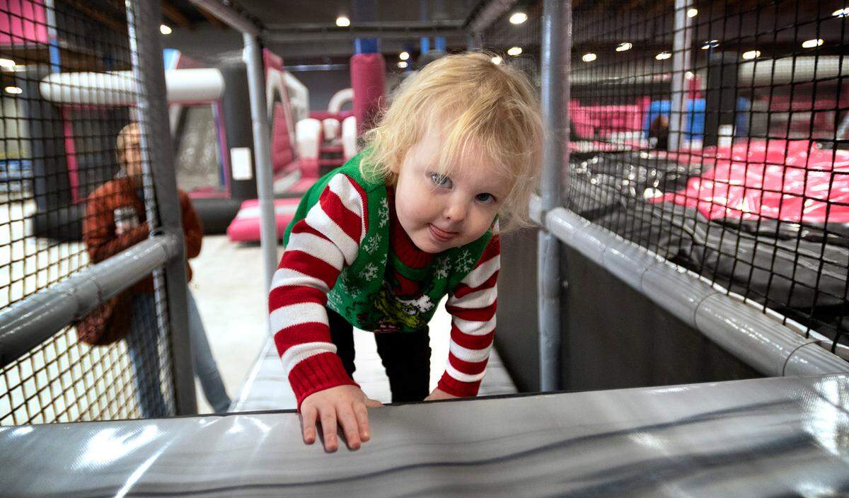 Raegen Hanlon, 2, of Puyallup, climbs a ladder walkway at Catapult Adventure Park in Puyallup, Washington, on Friday, Dec. 24, 2021.