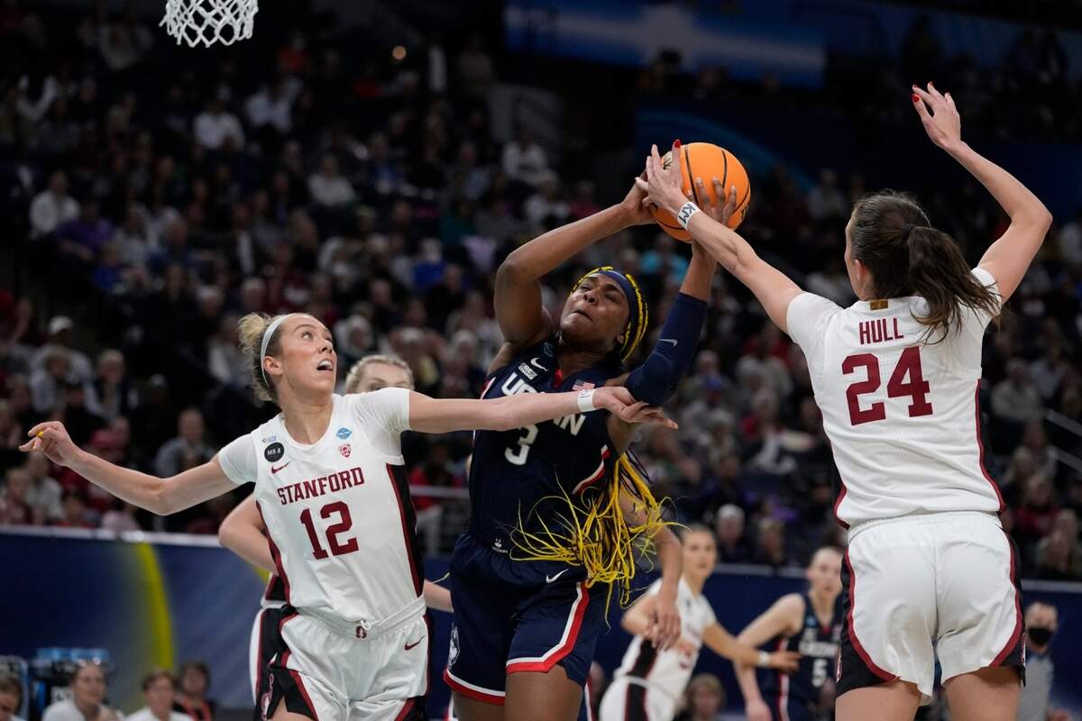 Stanford’s Lacie Hull and Lexie Hull stop UConn’s Aaliyah Edwards during the first half of a college basketball game in the semifinal round of the Women’s Final Four NCAA tournament Friday, April 1, 2022, in Minneapolis. (AP Photo/Charlie Neibergall)