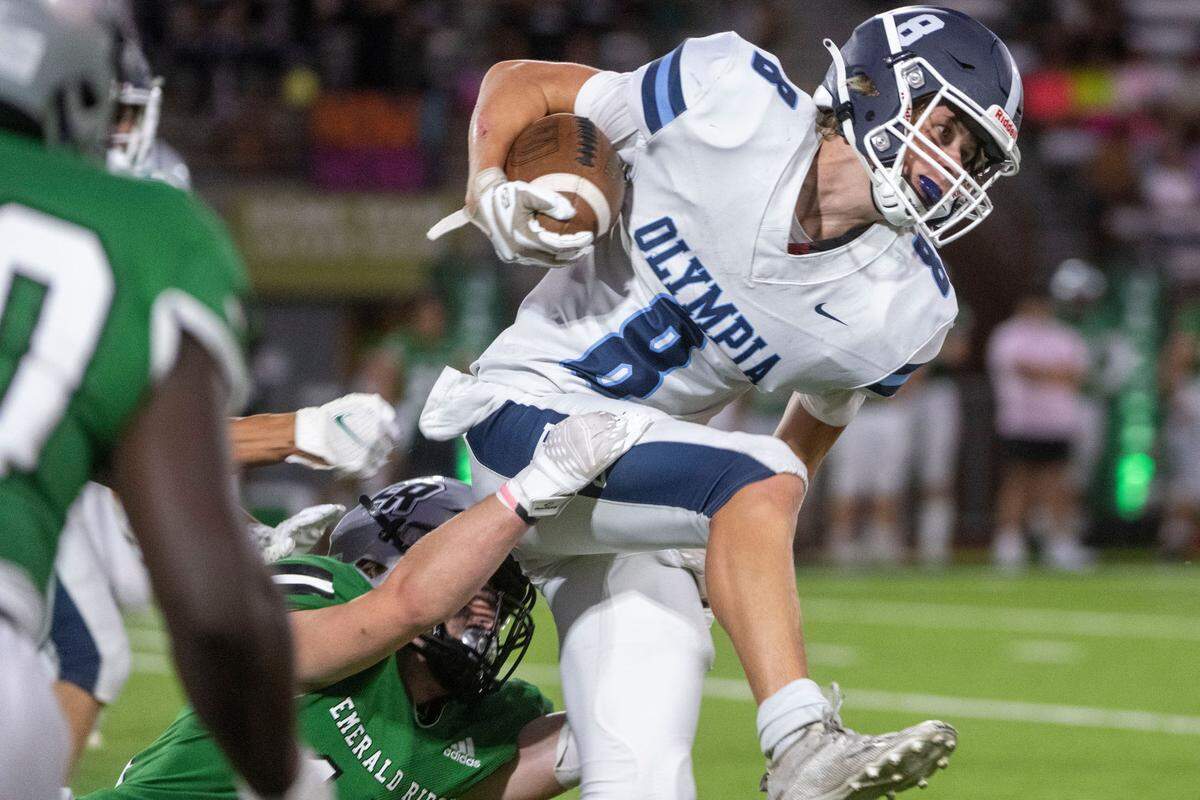 Olympia’s Drew Carlson breaks through a tackle attempt by an Emerald Ridge special teams player during a kick-off return in the second quarter of a 4A SPSL game at Sparks Stadium on Thursday, Sept. 8, 2022, in Puyallup, Wash.