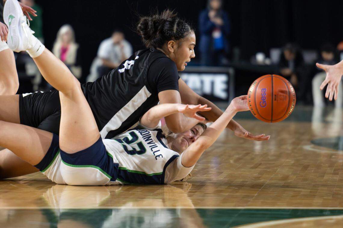 Sumner guard Kawehi Borden (4) dives for a loose ball with Woodinville guard Sam Harris (23) during the fourth quarter of a Class 3A state basketball tournament semifinal game at the Tacoma Dome on Friday, March 7, 2025, in Tacoma, Wash.