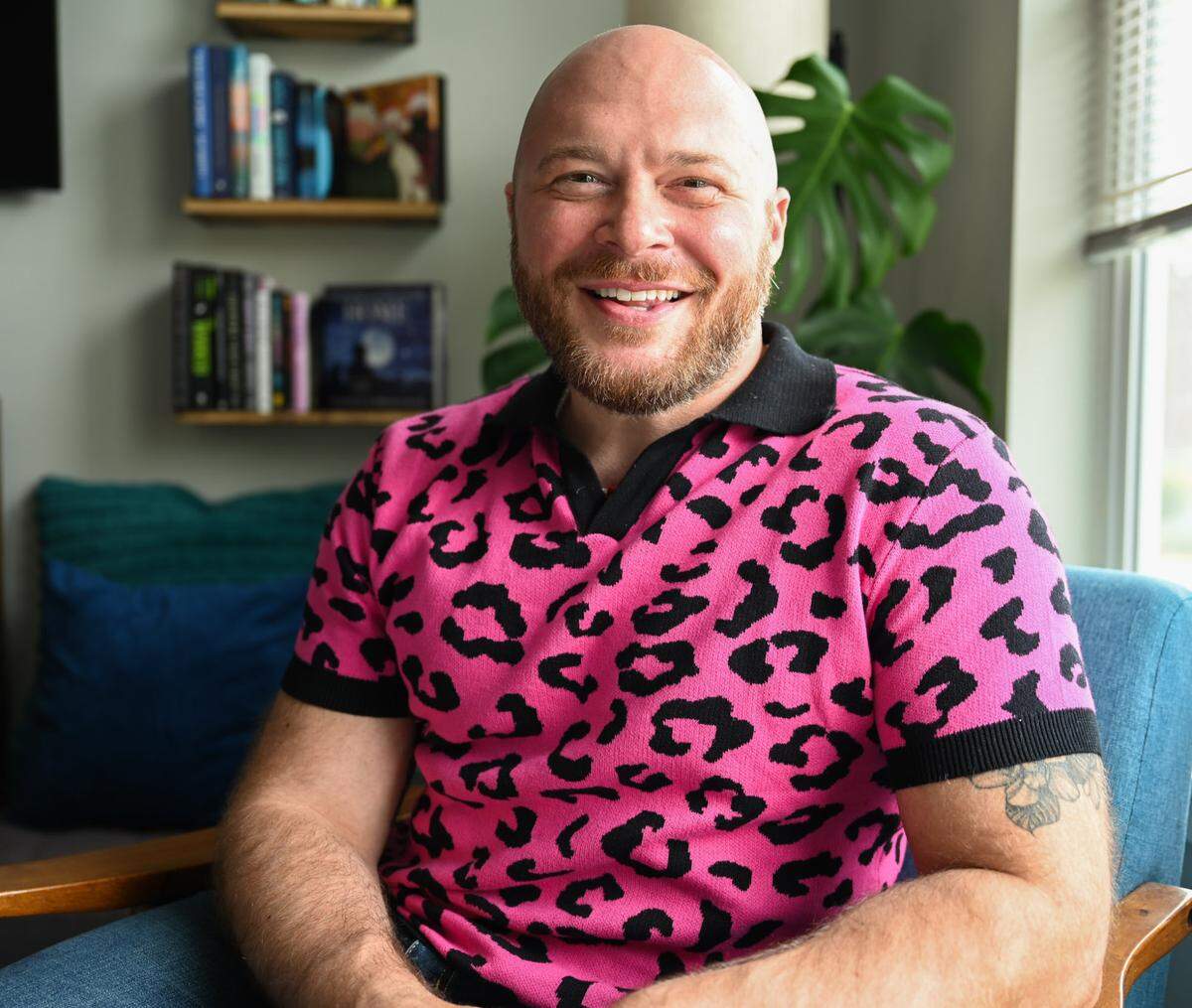 Travis Holp, a local psychic, poses for a portrait in his living room on Friday, Aug. 9, 2024 in Tacoma, WA. Holp became TikTok famous, amassing more than 468k followers, for his tarot reading and call himself the gay uncle of the spirit world.