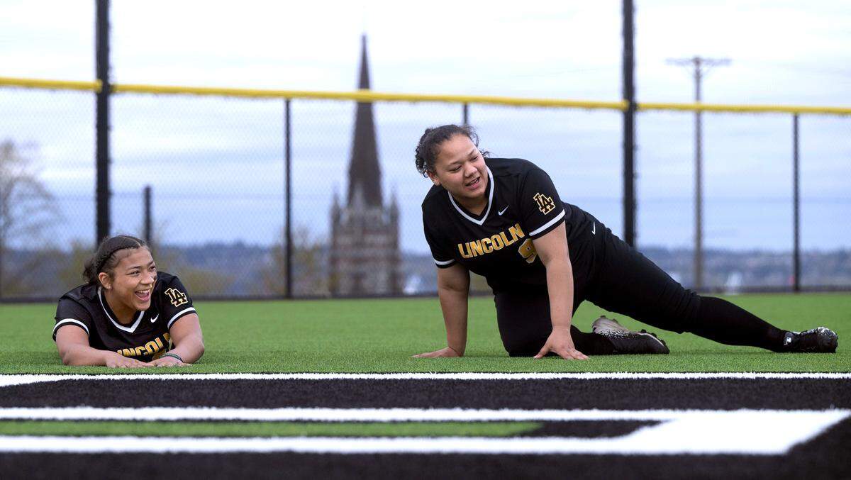 Lincoln fastpitch players and twin sisters Alexis Williams (left) and Alyssa Williams Kaydence Pugh warm up on the new turf field at Lincoln High School in Tacoma, Washington, on Monday, April 8, 2024.