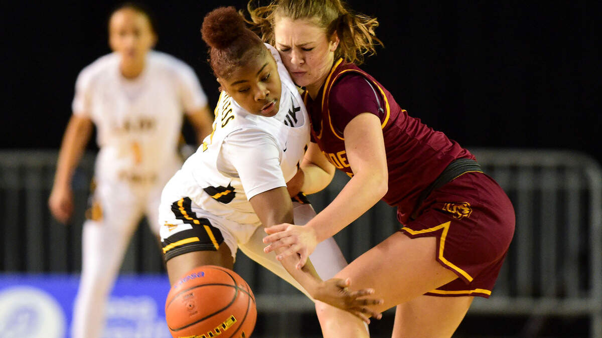 Lincoln guard Malani Warren (24) swipes at the ball while making contact with Lakeside guard Mia Broom (10) during the second quarter of a Class 3A state tournament game on Wednesday, March 2, 2022, at the Tacoma Dome, in Tacoma, Wash.
