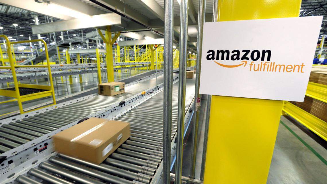 FILE - In this Feb. 13, 2015, file photo, a package moves along a conveyer belt during a media tour of the Amazon.com fulfillment center in DuPont, Wash. Amazon was fined after regulators said it was pressuring warehouse workers at the DuPont center to work at speeds that don’t give recovery time for injuries.