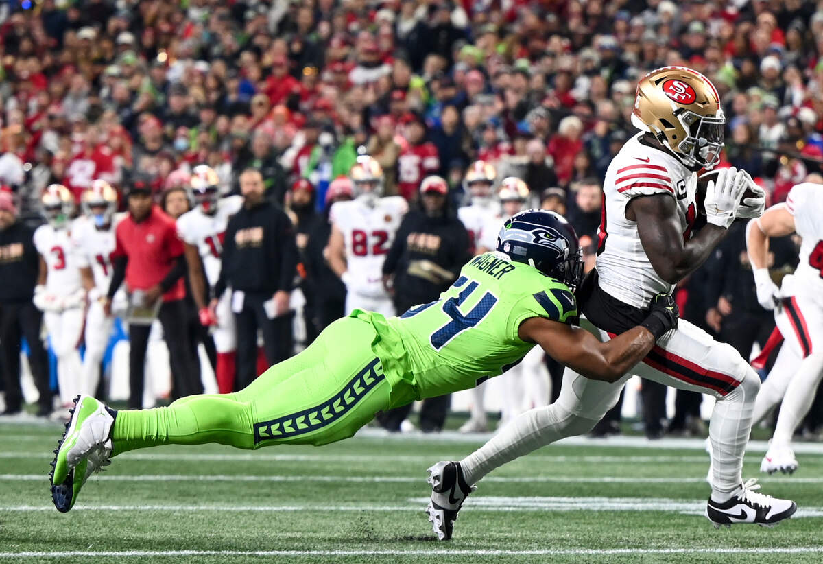 Seattle Seahawks linebacker Bobby Wagner (54) dives for the tackle on San Francisco 49ers wide receiver Deebo Samuel (19) during the first quarter of the game at Lumen Field, Thursday, Nov. 23, 2023, in Seattle, Wash.