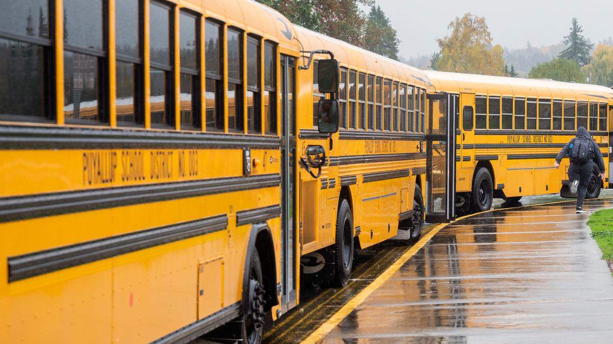 An Aylen Junior High School student runs through the rain toward his bus after school on Thursday afternoon in Puyallup.
