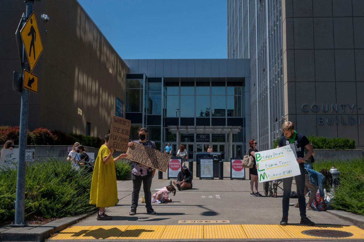 Protestors in support of Manny Ellis stand outside the County-City Building prior to the start of a motion hearing in Pierce County Superior on Friday, July 1, 2022. The hearing was on whether the city of Tacoma should be required to release internal interviews from police officers who were witnesses to the death of Manny Ellis.