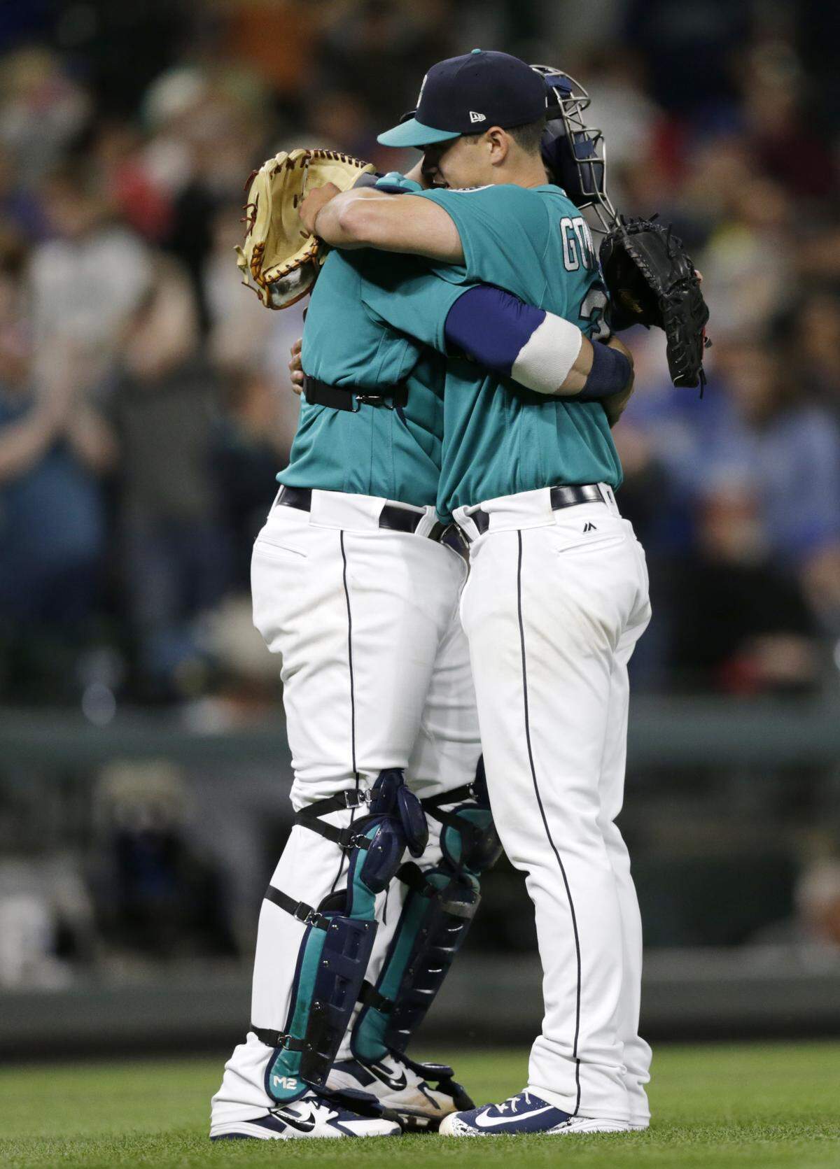 Seattle Mariners starting pitcher Marco Gonzales and catcher Mike Zunino hug after Gonzales threw a six-hitter in the team's 4-1 win over the Kansas City Royals in a baseball game Friday, June 29, 2018, in Seattle. (AP Photo/John Froschauer)