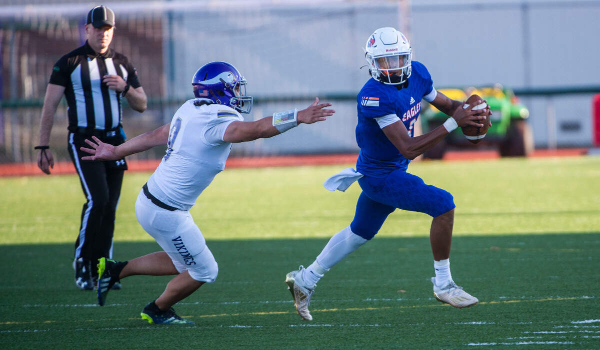 Eagles quarterback Joshua Wood darts away from Vikings defender Zack Brown in the third period of Graham Kapowsin’s 34-3 victory at Art Crate Field in Spanaway on Thursday, Sep. 23, 2021.